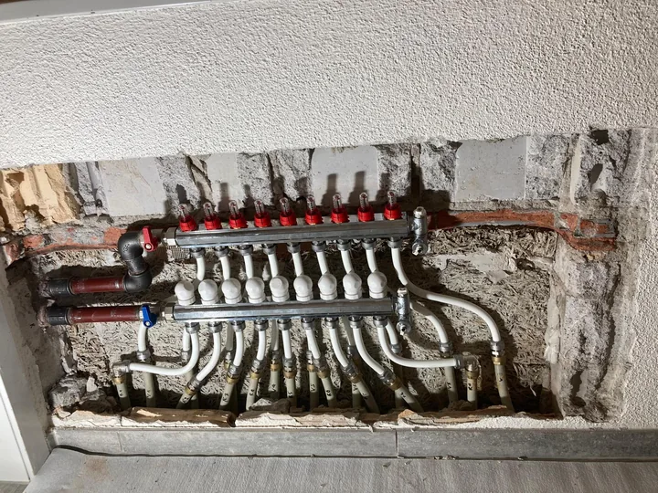 Neu montierter Bodenheizungsverteiler mit angeschlossenen Heizkreisen in Sirnach